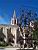 Avignon: een kerk met op de voorgrond een kunstwerk gemaakt van metalen constructies en druivenranken (243x)