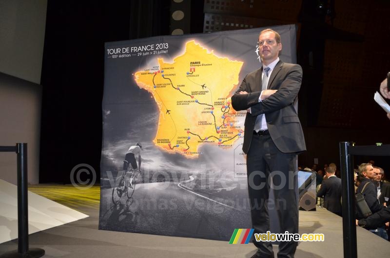 Christian Prudhomme poses next to the Tour de France 2013 map