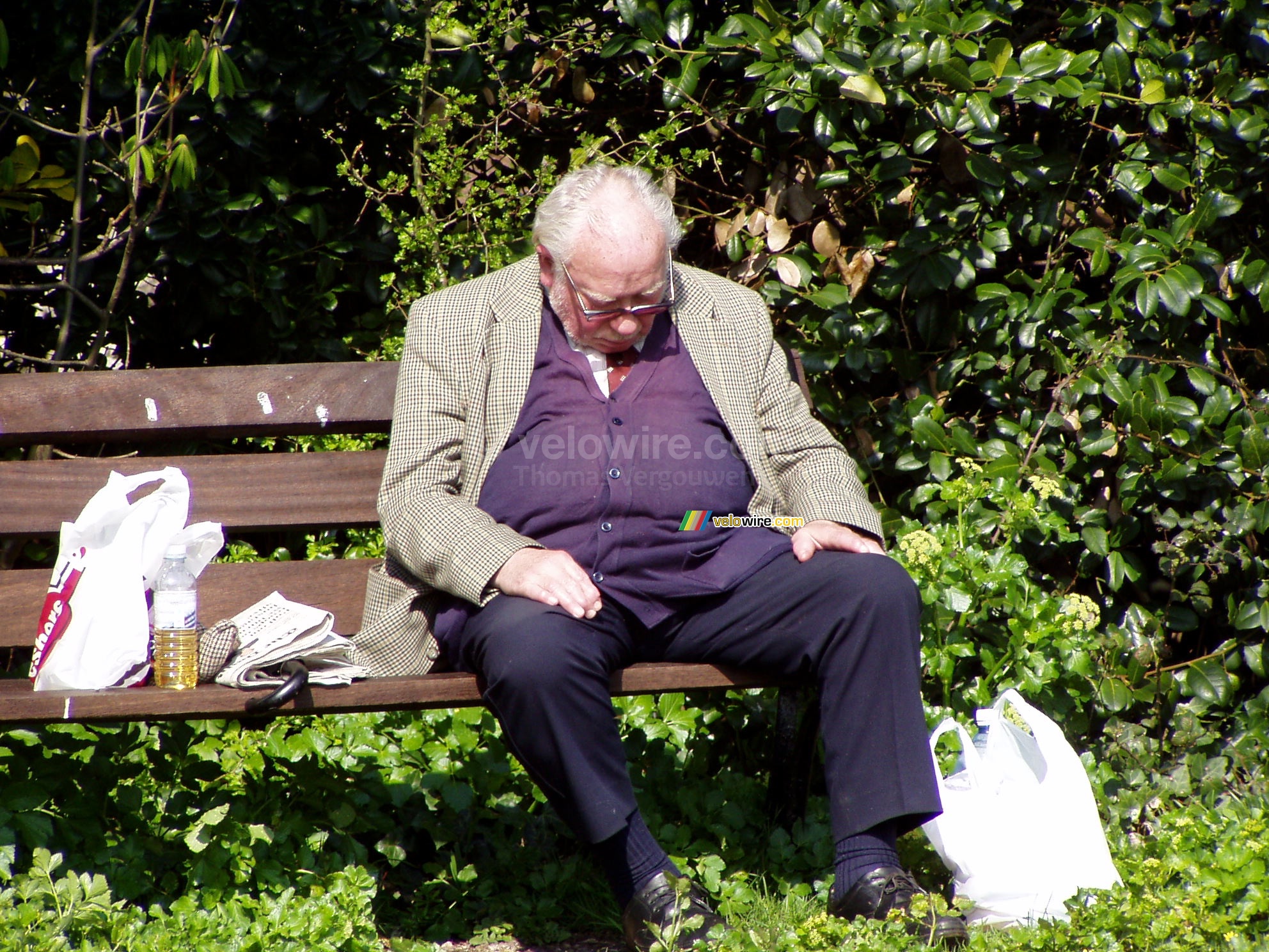 Een slapende man op een bank in een parkje in Bristol