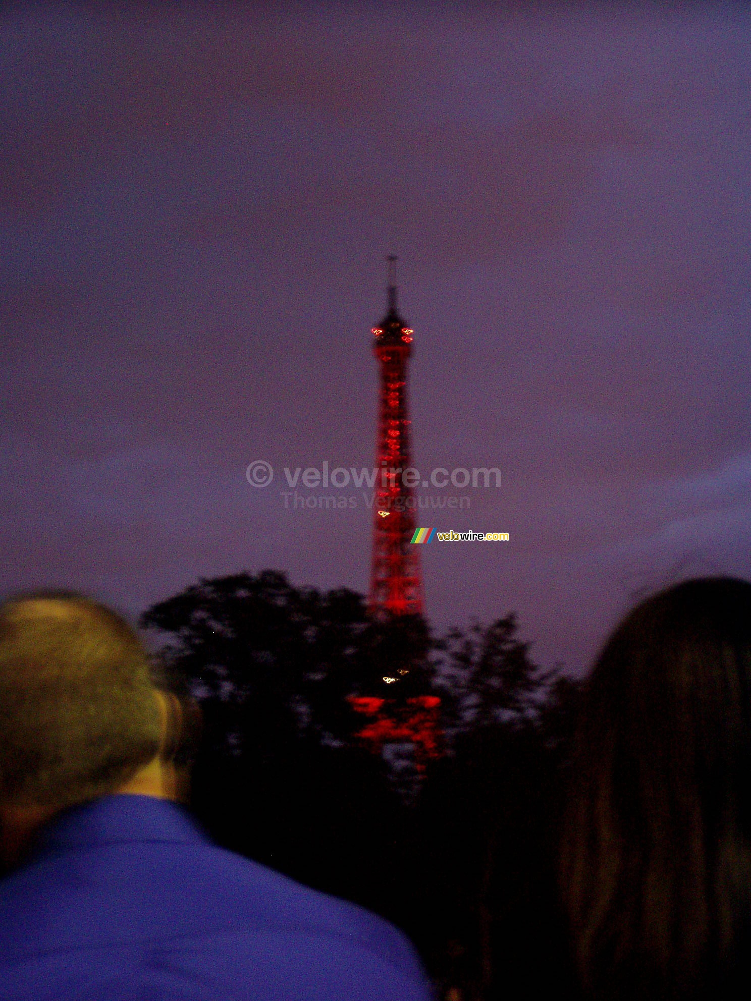 De Eiffeltoren rood verlicht voor het begin van het vuurwerk
