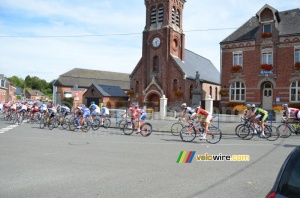 The peloton passes in front of the town hall and the church of Montay (335x)