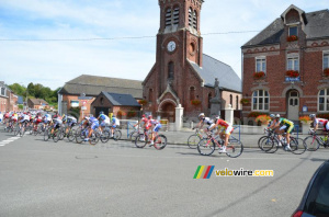 The peloton passes in front of the town hall and the church of Montay (335x)