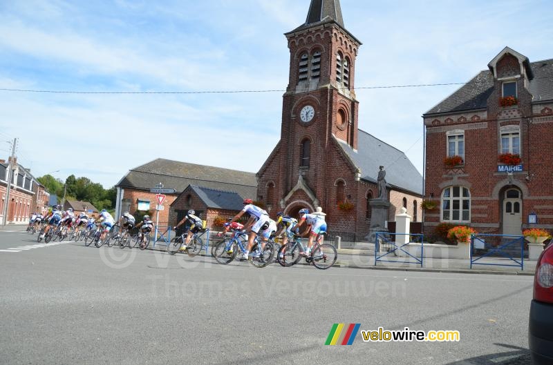 The peloton passes in front of the town hall and the church of Montay (2)
