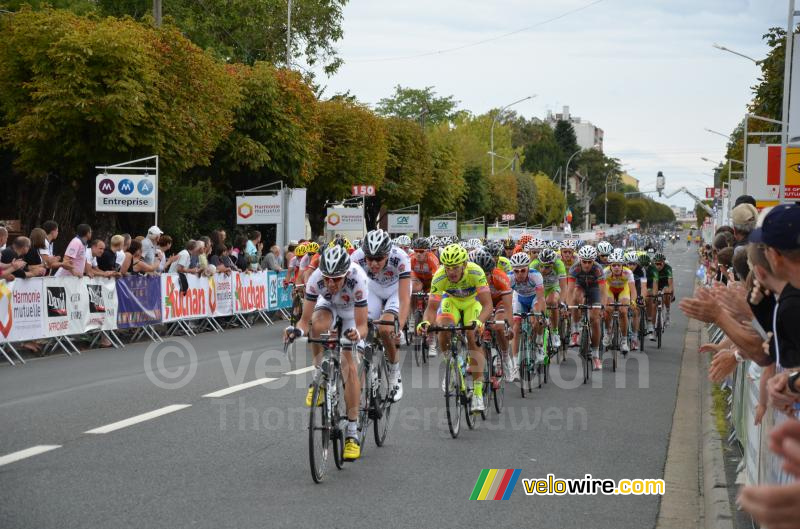 Het peloton bij de eerste doorkomst over de finishlijn