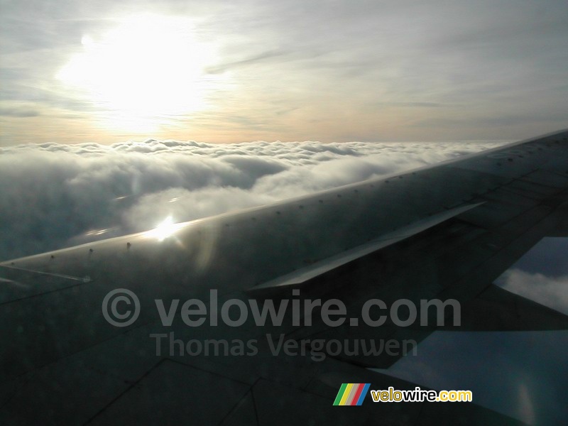 Wolken en de zon gezien vanuit het vliegtuig