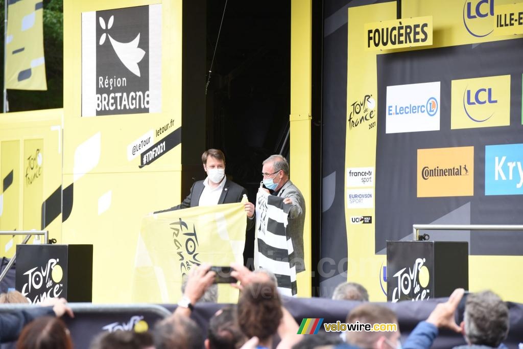 Loïg Chesnais-Girard en Bernard Hinault hebben de Bretonse vlag en die van de Tour de France uitgewisseld na het einde van het Grand Départ in Bretagne