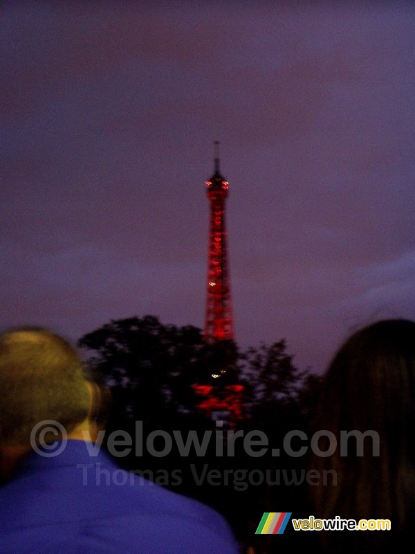 De Eiffeltoren rood verlicht voor het begin van het vuurwerk