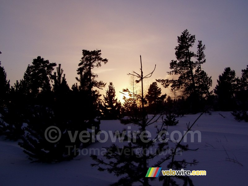 Le coucher du soleil dans un paysage hivernal