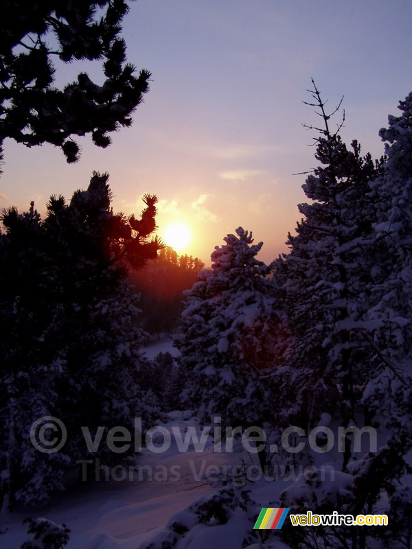 De zonsondergang in een winters landschap