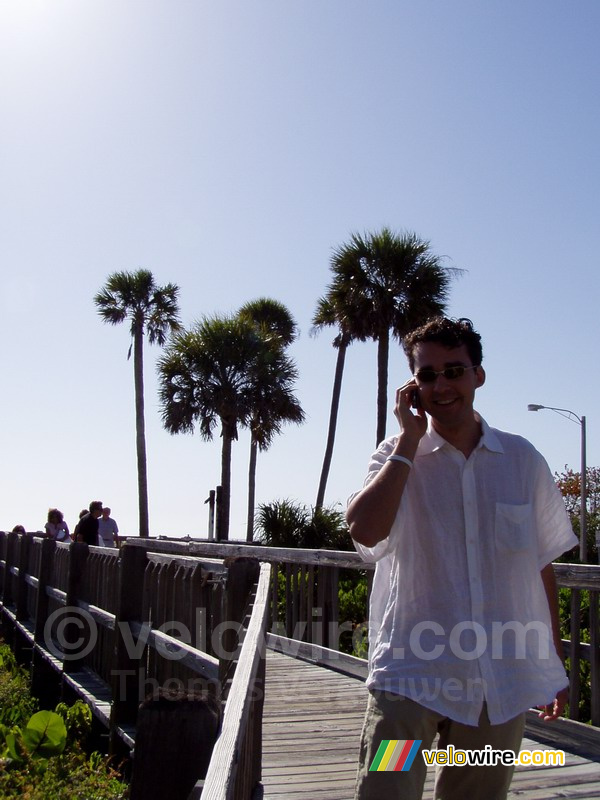 Romain aan de telefoon voor de palmbomen