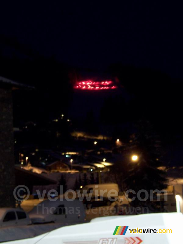 Des skieurs avec des flambeaux rouges descendent la piste