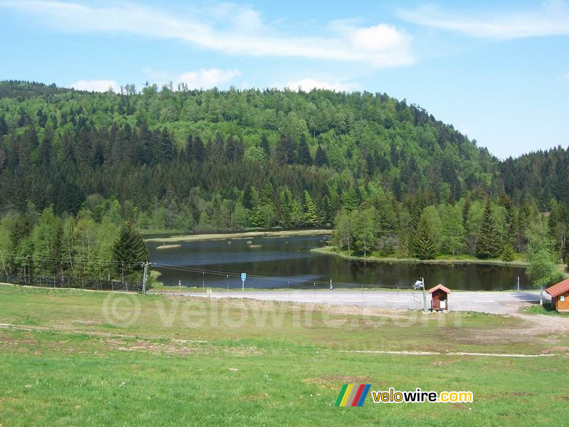 Een meer in de bossen met op de voorgrond een skilift