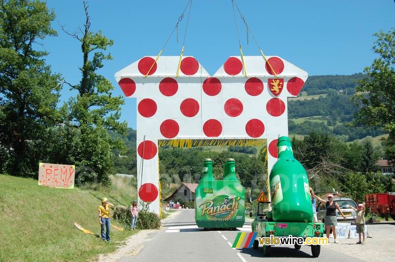 The Panach' advertising caravan passes under the polka dot jersey
