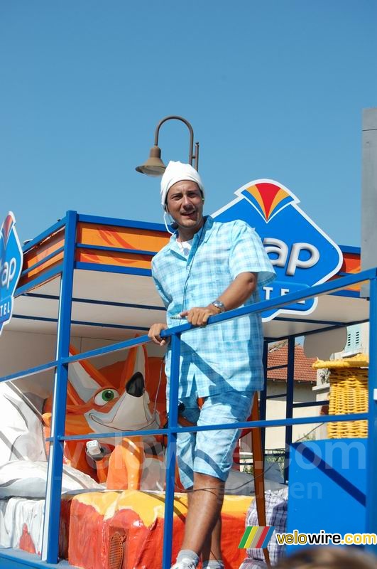 Un mec en pyjama sur le char de la caravane publicitaire Etap Hotel