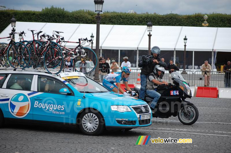 Een renner van Bouygues Telecom naast de ploegleiderswagen