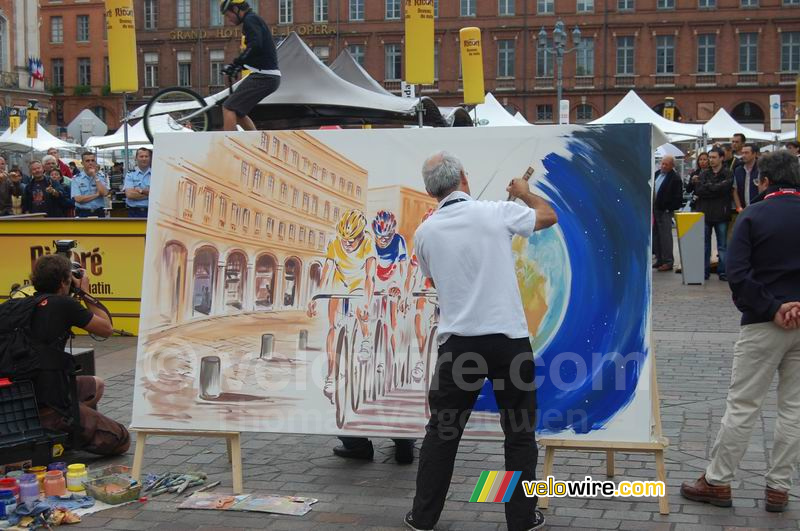 Animation au Village Départ : André Fuzin crée un tableau et Marc Vinco sur son VTT Trial