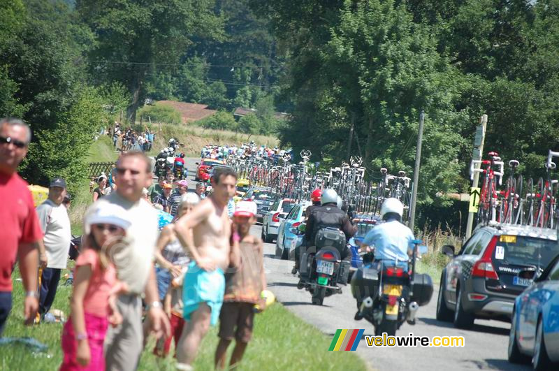 De stoet van auto's achter het peloton