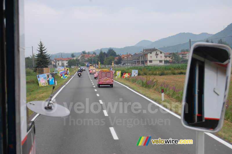 La caravane publicitaire Cochonou (droite) et la femme aux tableaux sur le cyclisme (gauche)