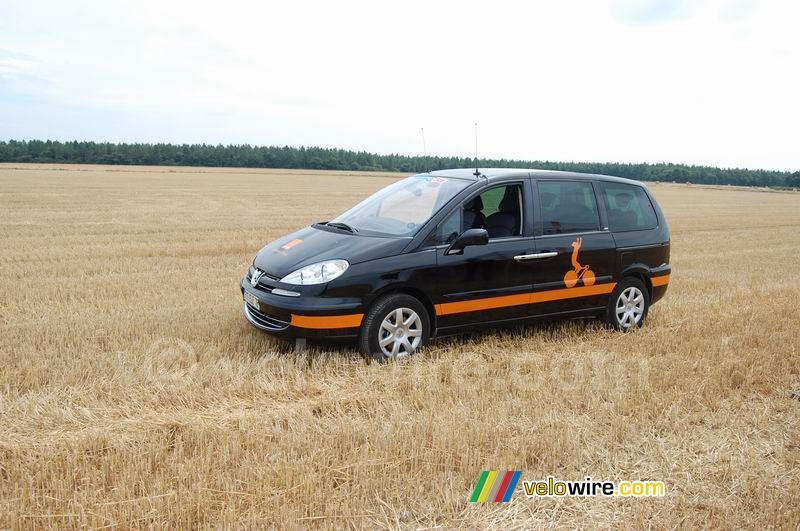 A Orange car in the middle of a big field!