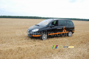 Une voiture Orange en plein milieu d'un grand champ ! (478x)