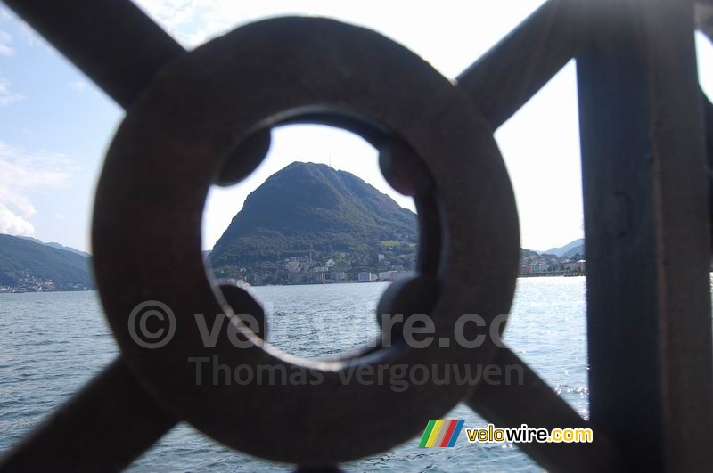 Uitzicht over het meer van Lugano naar Caprino - door het hek